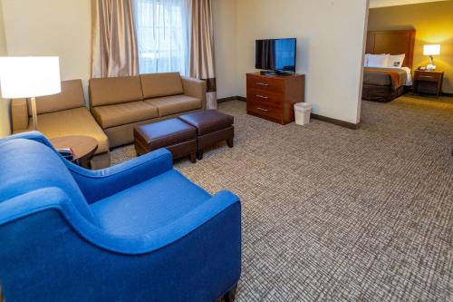 a hotel room with a blue couch and a living room at Comfort Inn Salt Lake City Downtown in Salt Lake City