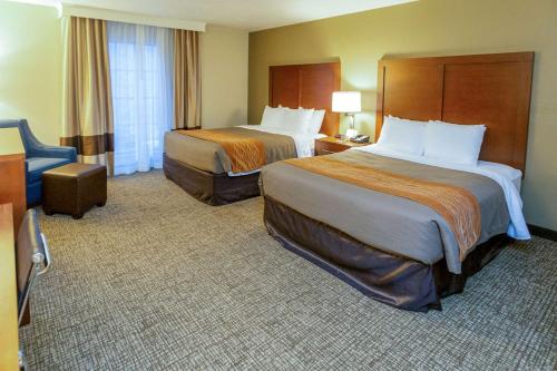 a hotel room with two beds and a chair at Comfort Inn Salt Lake City Downtown in Salt Lake City