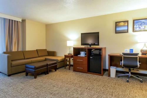 a hotel room with a couch and a flat screen tv at Comfort Inn Salt Lake City Downtown in Salt Lake City