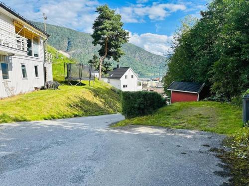 an empty road with a house and a basketball hoop at Prestadalen 6 in Sogndal