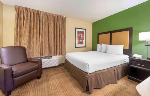 a hotel room with a bed and a chair at Extended Stay America Suites - Merrillville - US Rte 30 in Merrillville