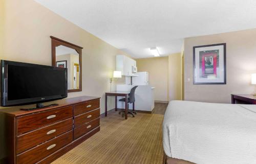a hotel room with a bed and a flat screen tv at Extended Stay America Suites - Tucson - Grant Road in Tucson