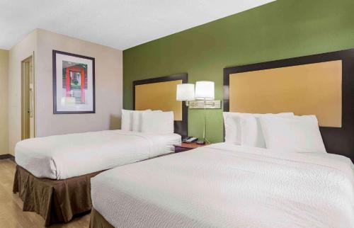 a hotel room with two beds with white sheets at Extended Stay America Suites - Tucson - Grant Road in Tucson