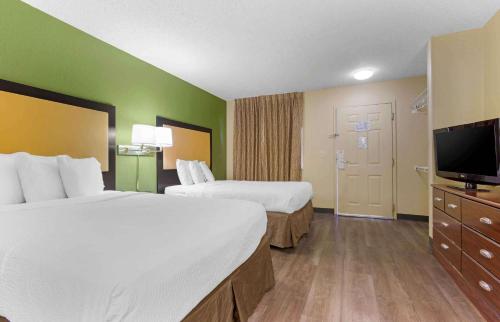 a hotel room with two beds and a flat screen tv at Extended Stay America Suites - Tucson - Grant Road in Tucson