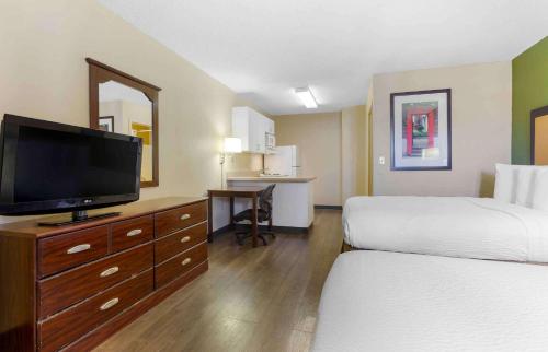 a hotel room with two beds and a flat screen tv at Extended Stay America Suites - Tucson - Grant Road in Tucson