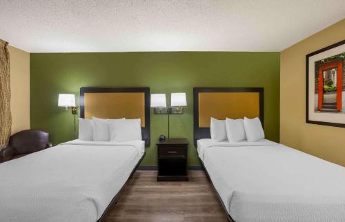 2 Betten in einem Zimmer mit grünen Wänden in der Unterkunft Extended Stay America Select Suites - Springfield - South in Springfield