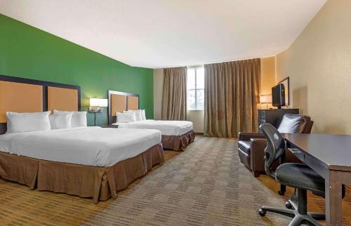 a hotel room with two beds and a desk at Extended Stay America Suites - Dallas - Frankford Road in Plano