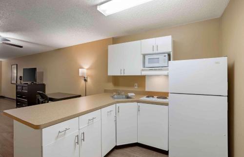 a kitchen with white cabinets and a white refrigerator at Extended Stay America Select Suites - Springfield - South in Springfield