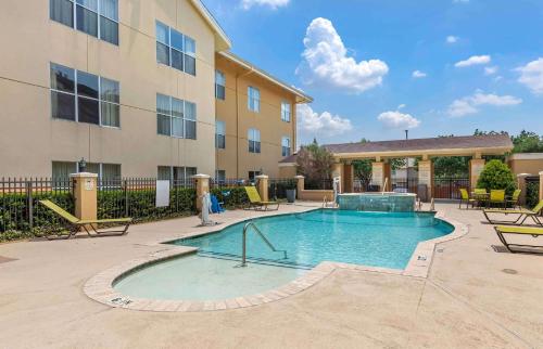una piscina con sillas y un edificio en Extended Stay America Suites - Dallas - Frankford Road en Plano