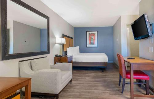 a hotel room with a bedroom with a bed and a mirror at Extended Stay America Suites - Kansas City - Lenexa - 87th St in Overland Park