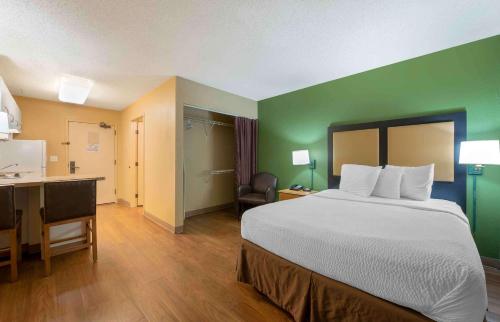Habitación de hotel con cama grande y escritorio. en Extended Stay America Suites - Chicago - Schaumburg - Convention Center, en Schaumburg