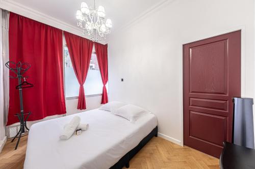 - une chambre avec un lit doté de rideaux rouges et d'une porte rouge dans l'établissement Villa Montmartre 4P-Sacré Cœur, à Paris