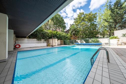 a large swimming pool with blue water at Villa Montmartre 4P-Sacré Cœur in Paris