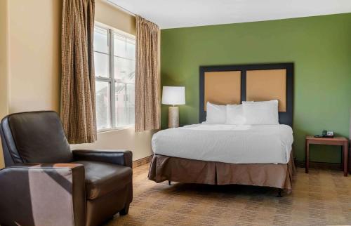 a hotel room with a bed and a chair at Extended Stay America Suites - Indianapolis - Airport - W Southern Ave in Indianapolis