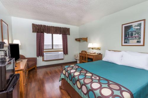 a hotel room with a bed and a television at Super 8 by Wyndham Gallipolis Pt Pleasant Area in Gallipolis