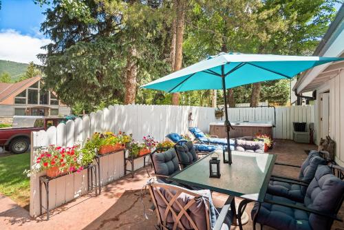 a patio with a table and an umbrella at Aspen West End Home in Aspen