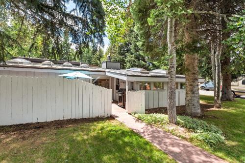 a white house with a fence in a yard at Aspen West End Home in Aspen