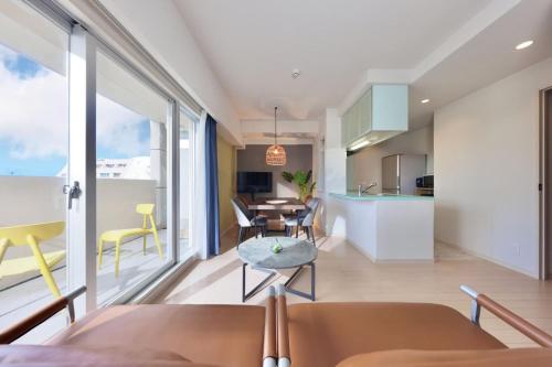 a kitchen and living room with a table and chairs at City Life Miyako L'avenir in Miyako-jima