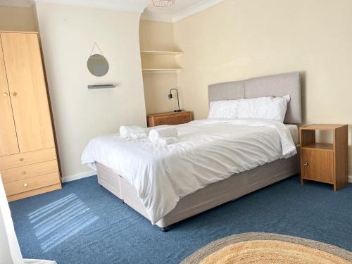 a bedroom with a large bed with white sheets at Canterbury King bed house with Free Parking & Garden in Canterbury