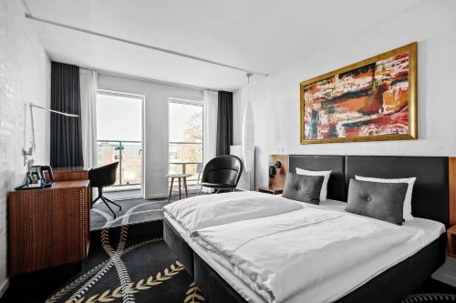 una camera con letto, scrivania e sedia di Best Western Plus Hotel Eyde a Herning