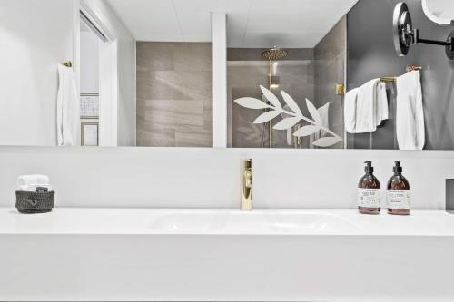 a bathroom with a sink and a mirror at Best Western Plus Hotel Eyde in Herning