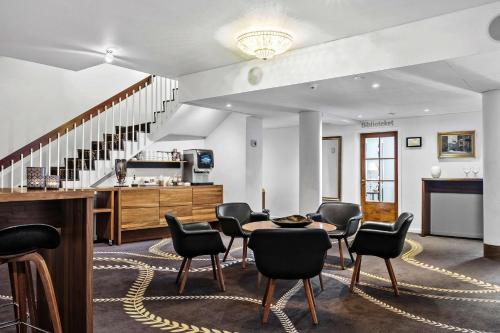 a room with a table and chairs and stairs at Best Western Plus Hotel Eyde in Herning