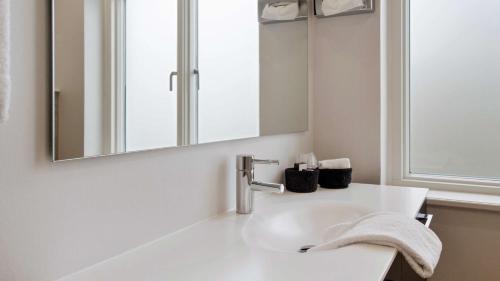 a white bathroom with a sink and a mirror at Best Western Plus Hotel Eyde in Herning