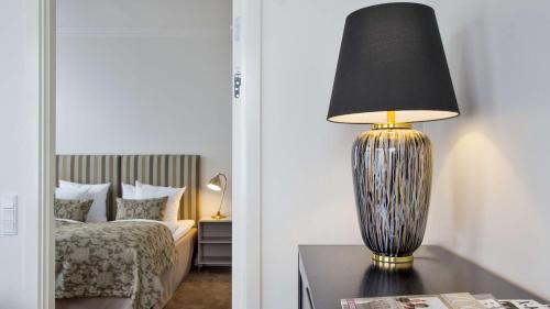 a lamp sitting on a table next to a bed at Best Western Plus Hotel Eyde in Herning