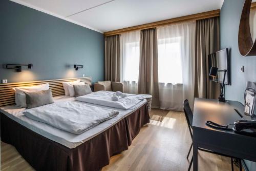 a hotel room with a bed and a desk at Scandic Ringsted in Ringsted
