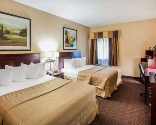 Quality Inn & Suites في بيوريا: غرفة فندقية بسريرين ومكتب
