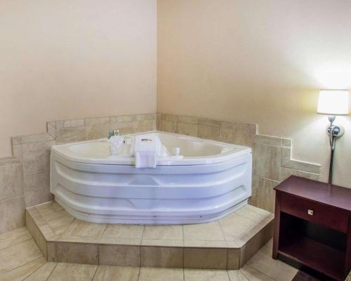 La salle de bains est pourvue d'une grande baignoire et d'une table. dans l'établissement Quality Inn & Suites, à Peoria