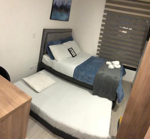 ein kleines Schlafzimmer mit 2 Betten und einem Fenster in der Unterkunft Cómodo Apartamento en Bogotá, Chapinero Central - Theatron in Bogotá