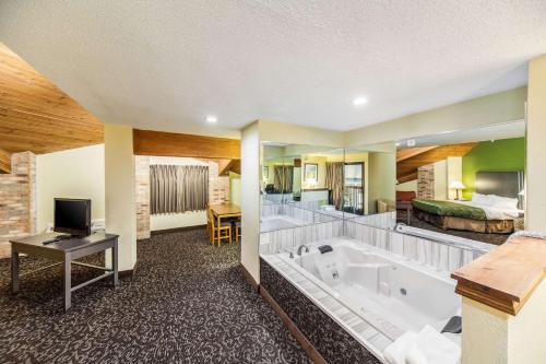 Habitación de hotel con bañera grande y dormitorio en Quality Inn Decatur near US-224, en Decatur