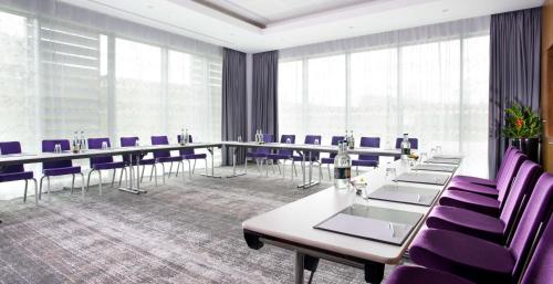 a conference room with long tables and purple chairs at Radisson Blu Hotel East Midlands Airport in Castle Donington