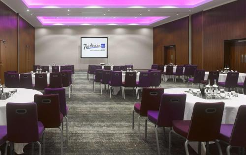 a conference room with tables and purple chairs at Radisson Blu Hotel East Midlands Airport in Castle Donington