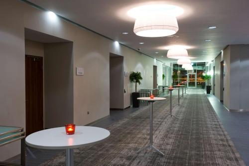 a row of tables in a hallway with lights at Radisson Blu Hotel East Midlands Airport in Castle Donington