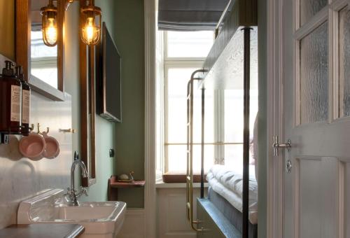 a bathroom with a sink and a mirror and a window at Hotel Frantz, WorldHotels Crafted in Stockholm