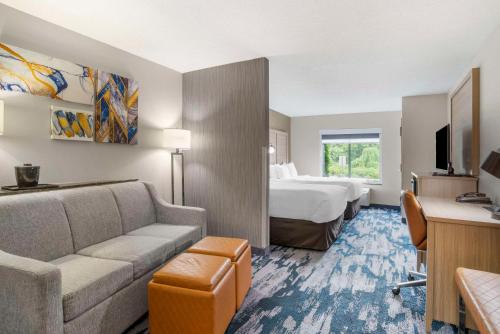a hotel room with a bed and a couch at Comfort Suites At WestGate Mall in Spartanburg