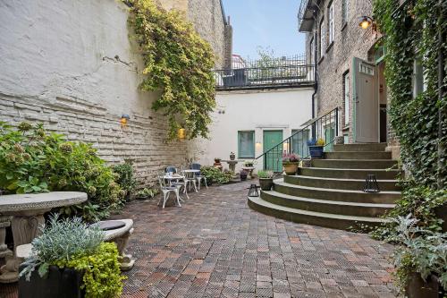 a brick courtyard with stairs and tables and chairs at Hotell Linnéa - Helsingborg in Helsingborg