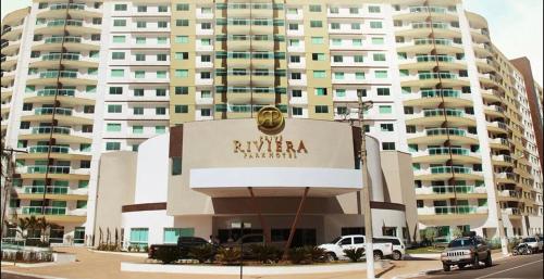 a large apartment building with a sign in front of it at Riviera Park Hotel Luxo in Caldas Novas