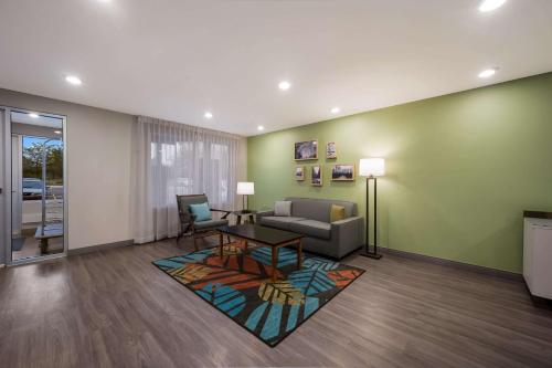 a living room with a couch and a table at WoodSpring Suites Wixom - Novi in Wixom