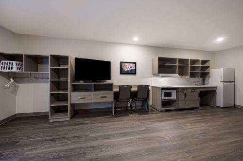 an office with a desk with a computer and a refrigerator at WoodSpring Suites Wixom - Novi in Wixom