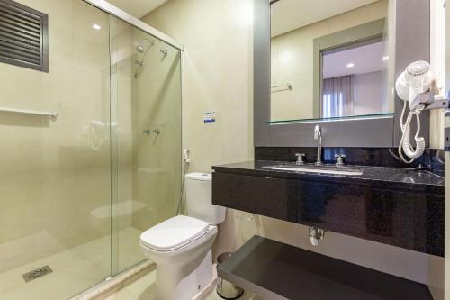 a bathroom with a toilet and a shower and a sink at Aion Suítes - Luxuoso Loft, Praia de Bombinhas in Bombinhas