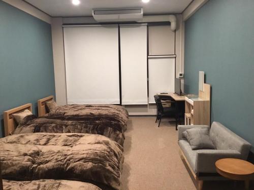 - une chambre avec 2 lits, un bureau et un canapé dans l'établissement Iitoko - Vacation STAY 43595v, à Iitoyo