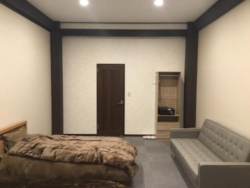 ein Schlafzimmer mit einem Bett und einem Sofa in der Unterkunft Iitoko - Vacation STAY 43906v in Iitoyo
