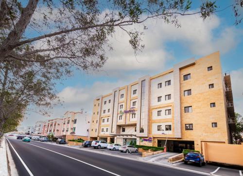 a street with buildings and cars parked on the side of a road at Staytion First - Al Zahra in Jeddah