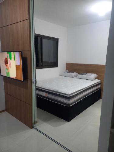 a bedroom with a bed and a mirror at Apartamento Temporada Salvador Pituba in Salvador