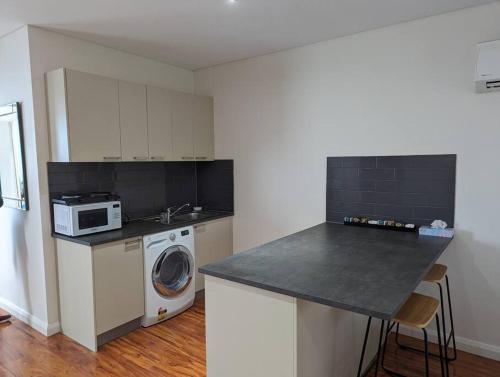 a kitchen with a washing machine and a microwave at Spacious 2 bedroom apartment @Kingston Foreshore in Kingston 