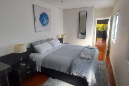 a bedroom with a bed and a lamp and a window at Spacious 2 bedroom apartment @Kingston Foreshore in Kingston 