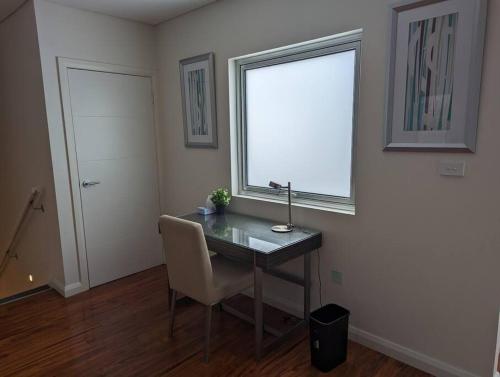 a room with a desk with a chair and a window at Spacious 2 bedroom apartment @Kingston Foreshore in Kingston 